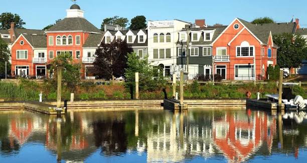 Colorful waterfront buildings reflected on the water in Milford